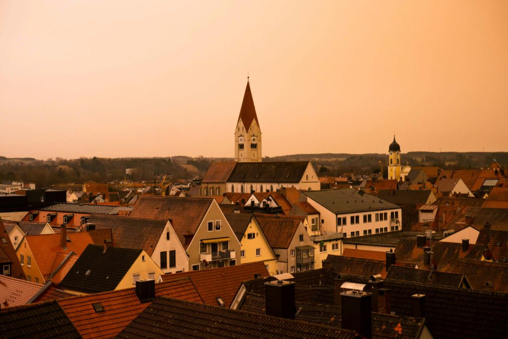 Explore a picturesque sunset over Kaufbeuren's rooftops and iconic church towers.